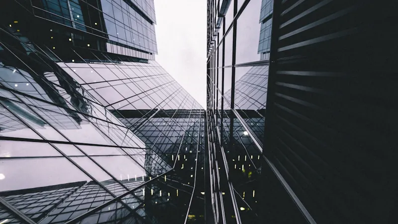 Reflective glass office facades in Canary Wharf, an editorial image for research on digital-asset custody.
