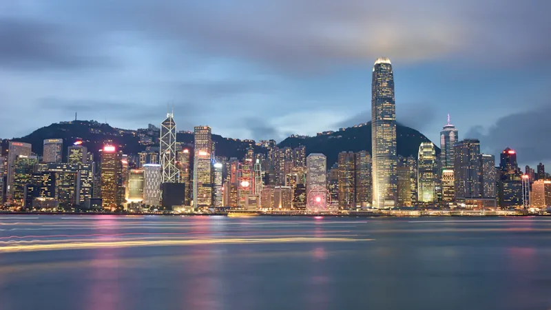 Hong Kong skyline across Victoria Harbour at dusk, illustrating research on cross-border trust taxation.